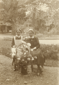 826200 Portret van de diaconessen Ytje Dijkstra (links, 1896-1968) en Gonda Vasseur (1894-1977) in de tuin van het ...